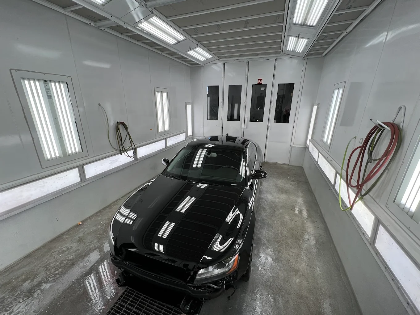 Black sedan in Best Auto's paint booth